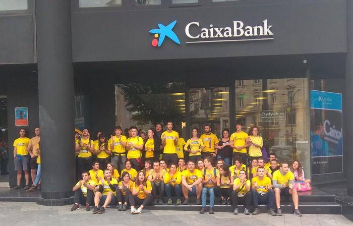 Hainbat gaztek Kataluniaren aldeko protesta egin dute La Caixak Bilbon duen egoitzaren sarreran